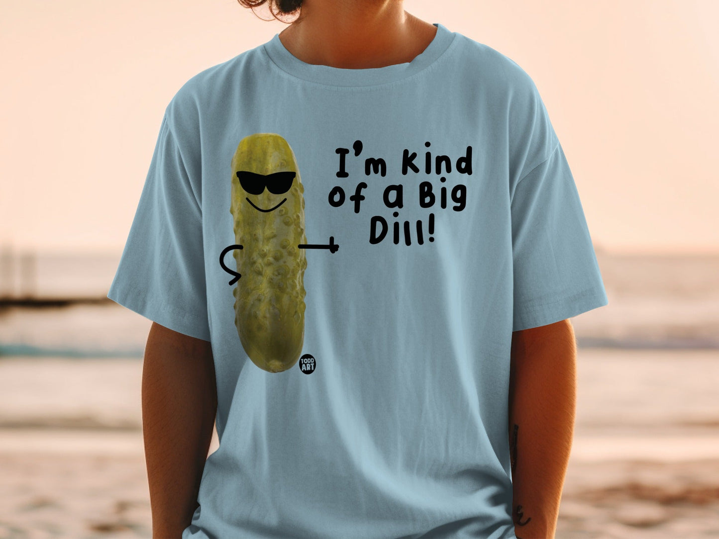 Light blue t-shirt with cartoon pickle wearing sunglasses and saying "I'm kind of a Big Dill!"