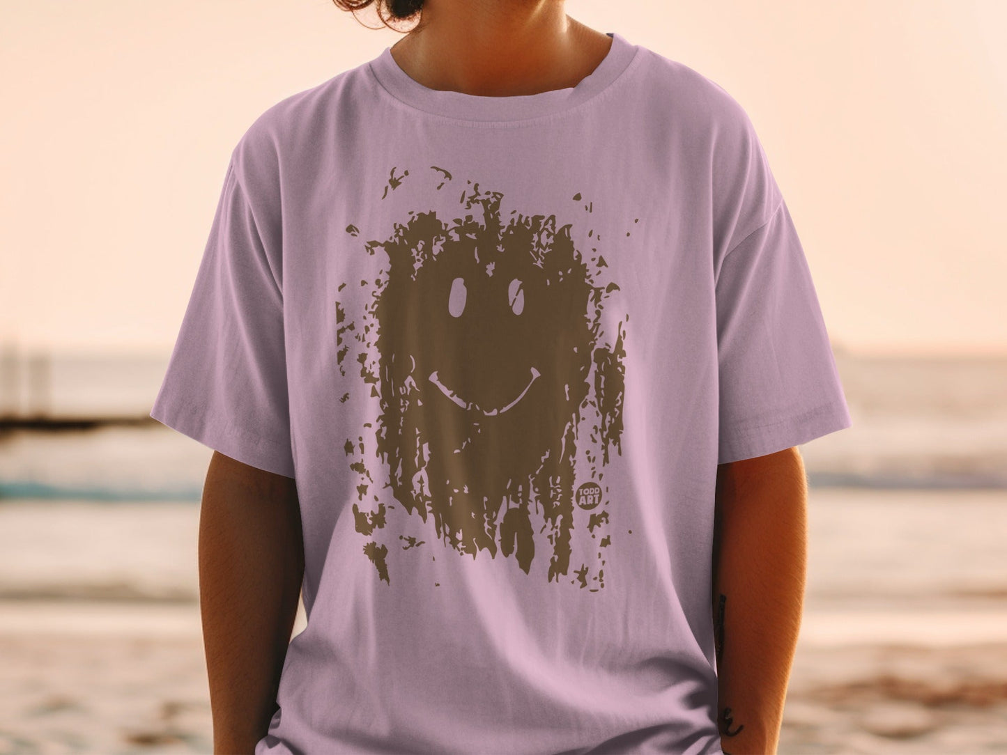 Lavender t-shirt with brown smiley face graphic.