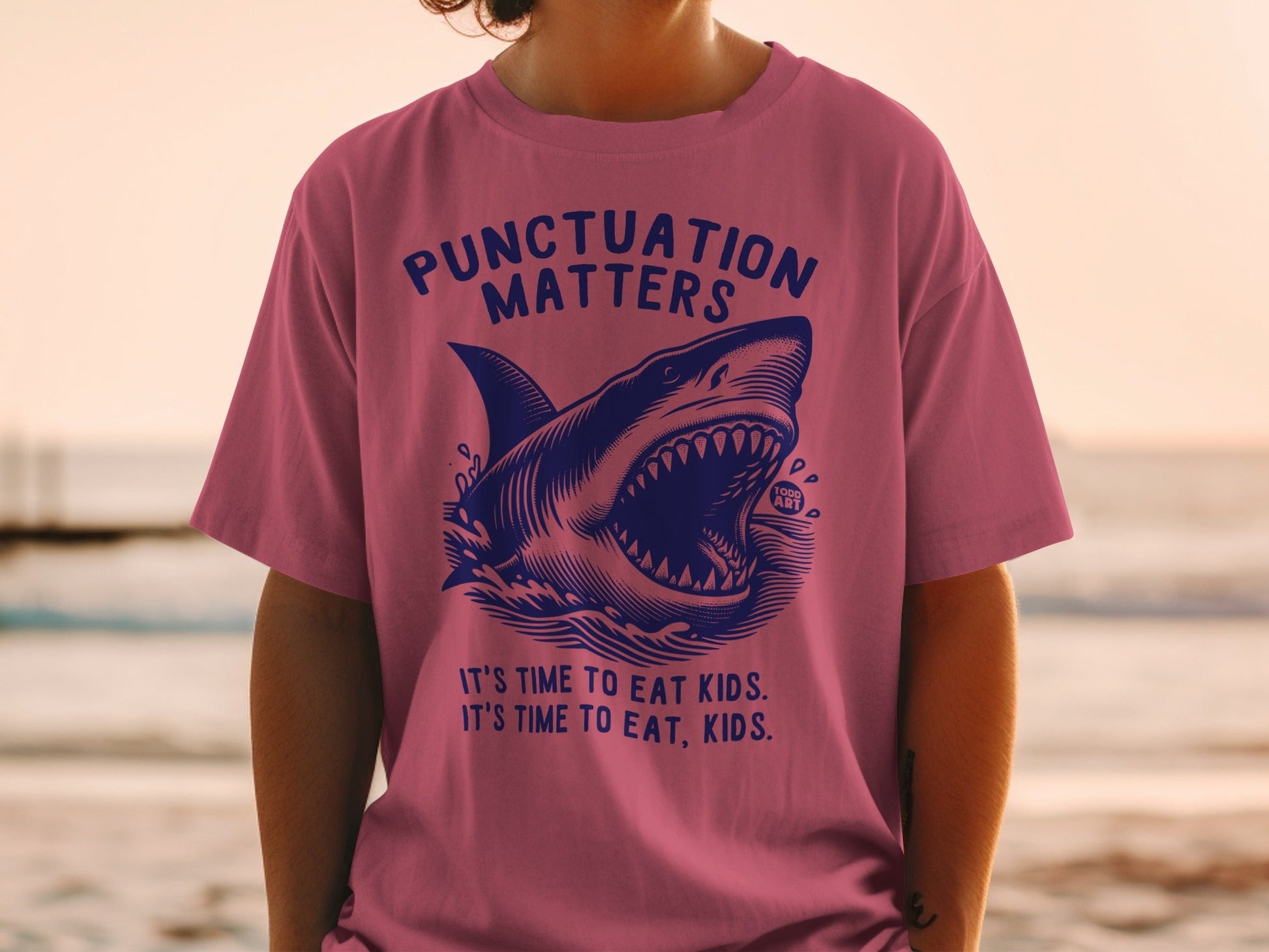 Pink t-shirt with a shark and text about punctuation.