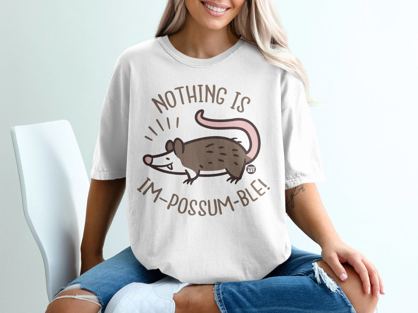 White t-shirt with a cartoon possum and "NOTHING IS IM-POSSUM-BLE!" text.