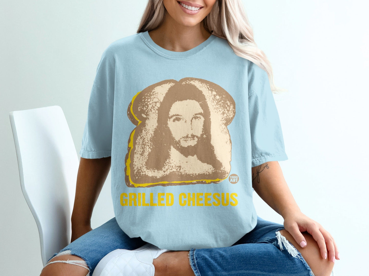 Light blue t-shirt with grilled cheese and Jesus graphic, text "GRILLED CHEESUS".