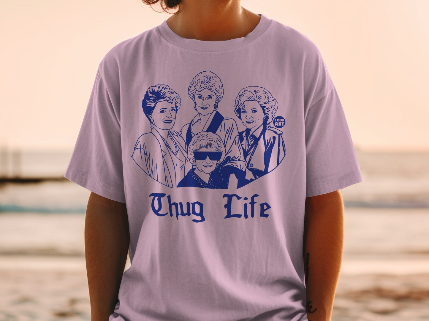 Illustration of the Golden Girls cast on a light purple t-shirt.