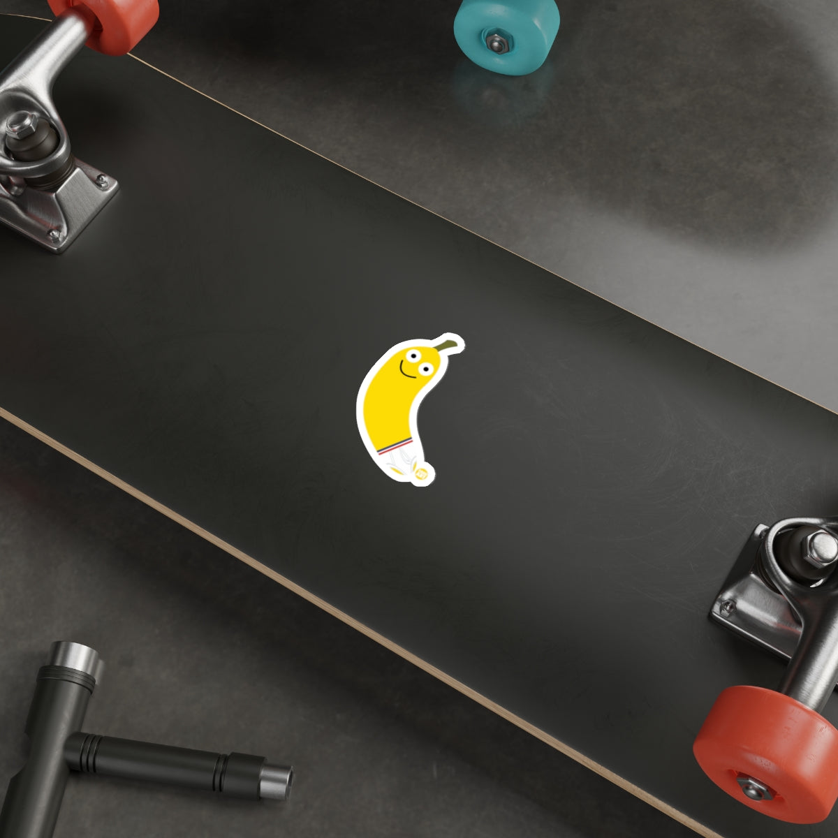 Smiling Banana Sticker on Black Skateboard Deck
