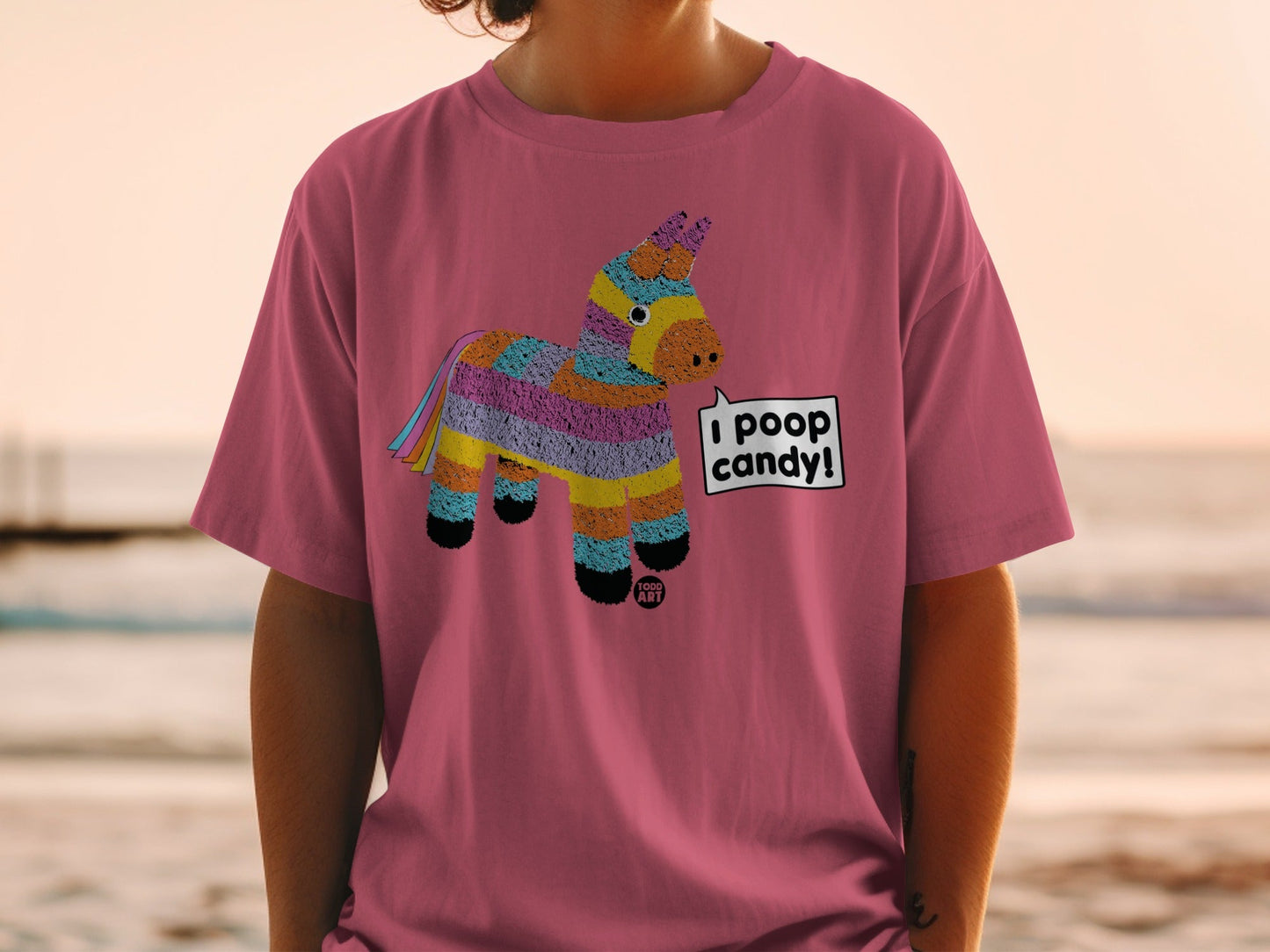 Pink t-shirt with colorful pinata graphic saying "I poop candy."