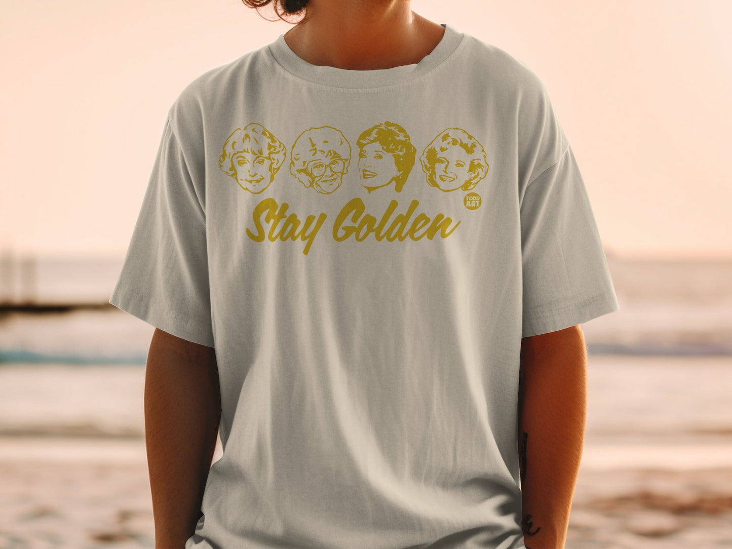 T-shirt with cartoon portraits of The Golden Girls and "Stay Golden" text.