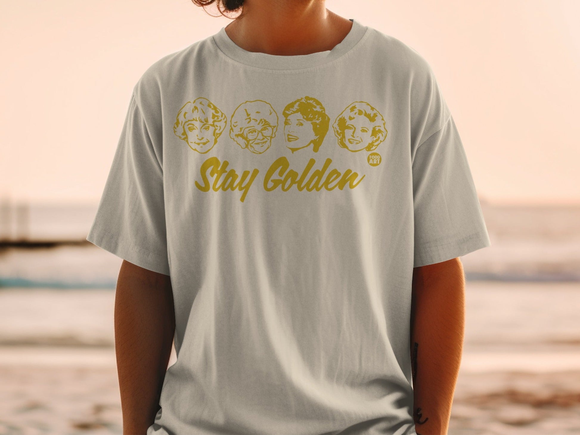 T-shirt with cartoon portraits of The Golden Girls and "Stay Golden" text.