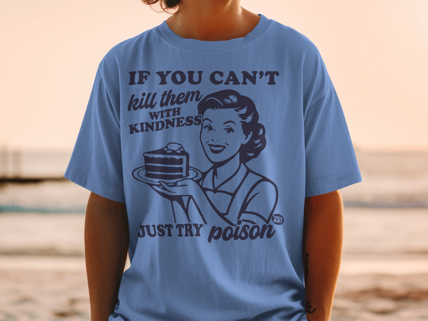 Blue t-shirt with "If you can't kill them with kindness, just try poison" text and retro woman with cake.