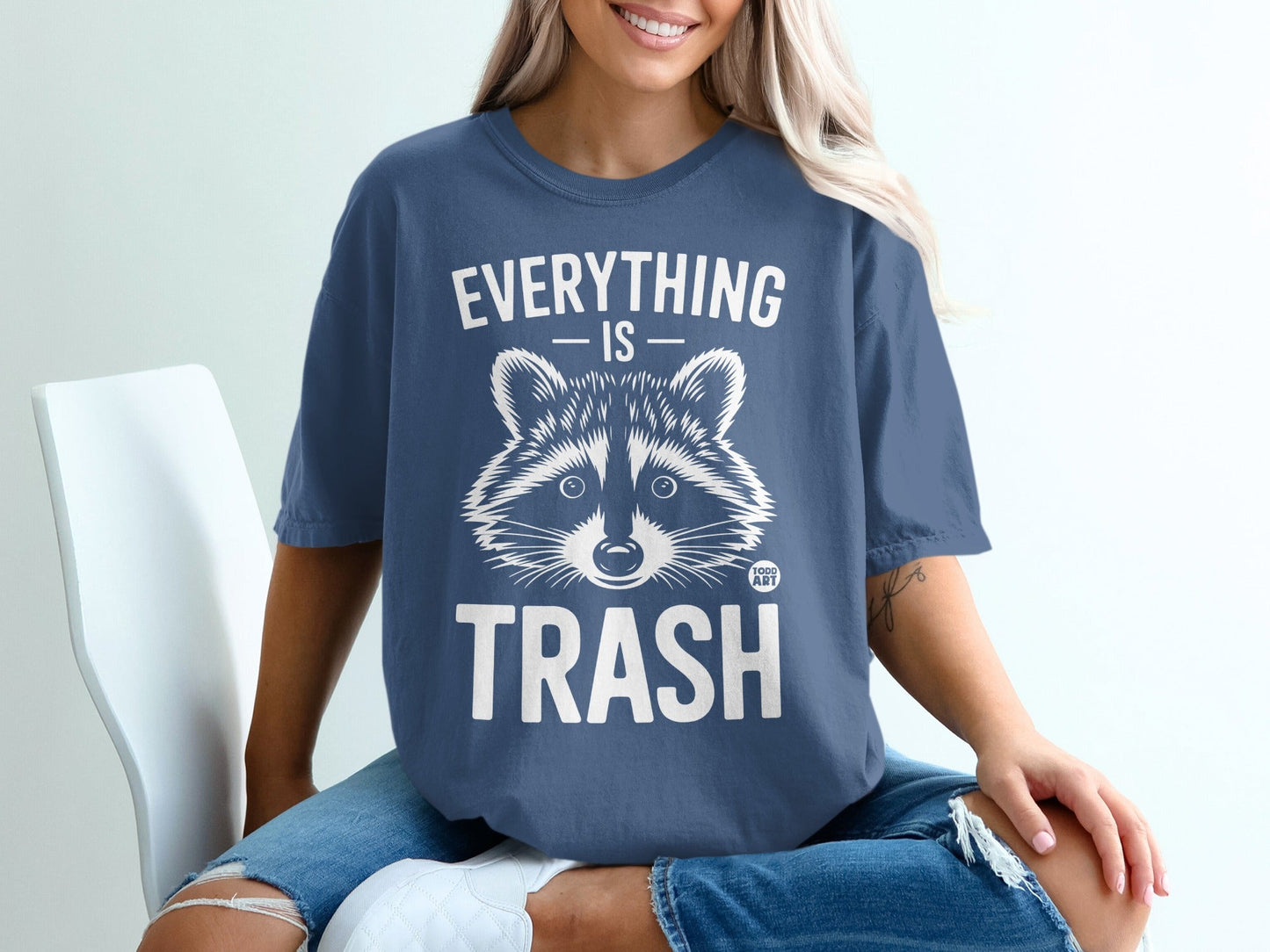 Blue t-shirt with raccoon graphic and text "Everything is Trash".