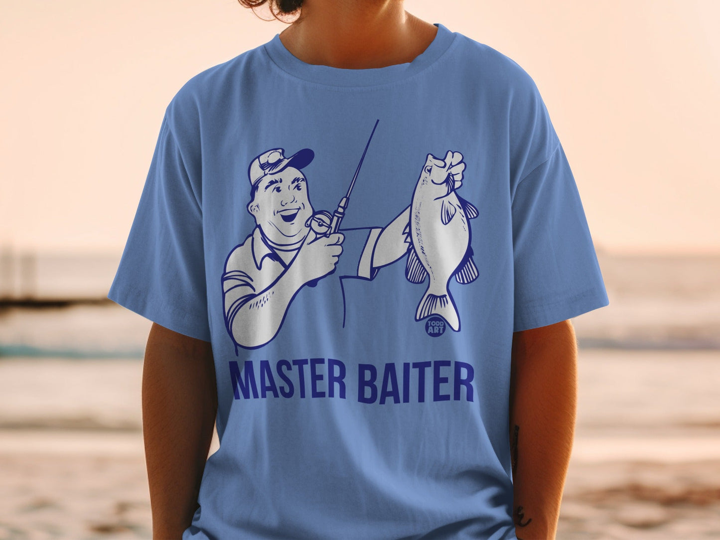 Blue t-shirt with cartoon angler holding a fish, text "MASTER BAITER" and "TODD ART".