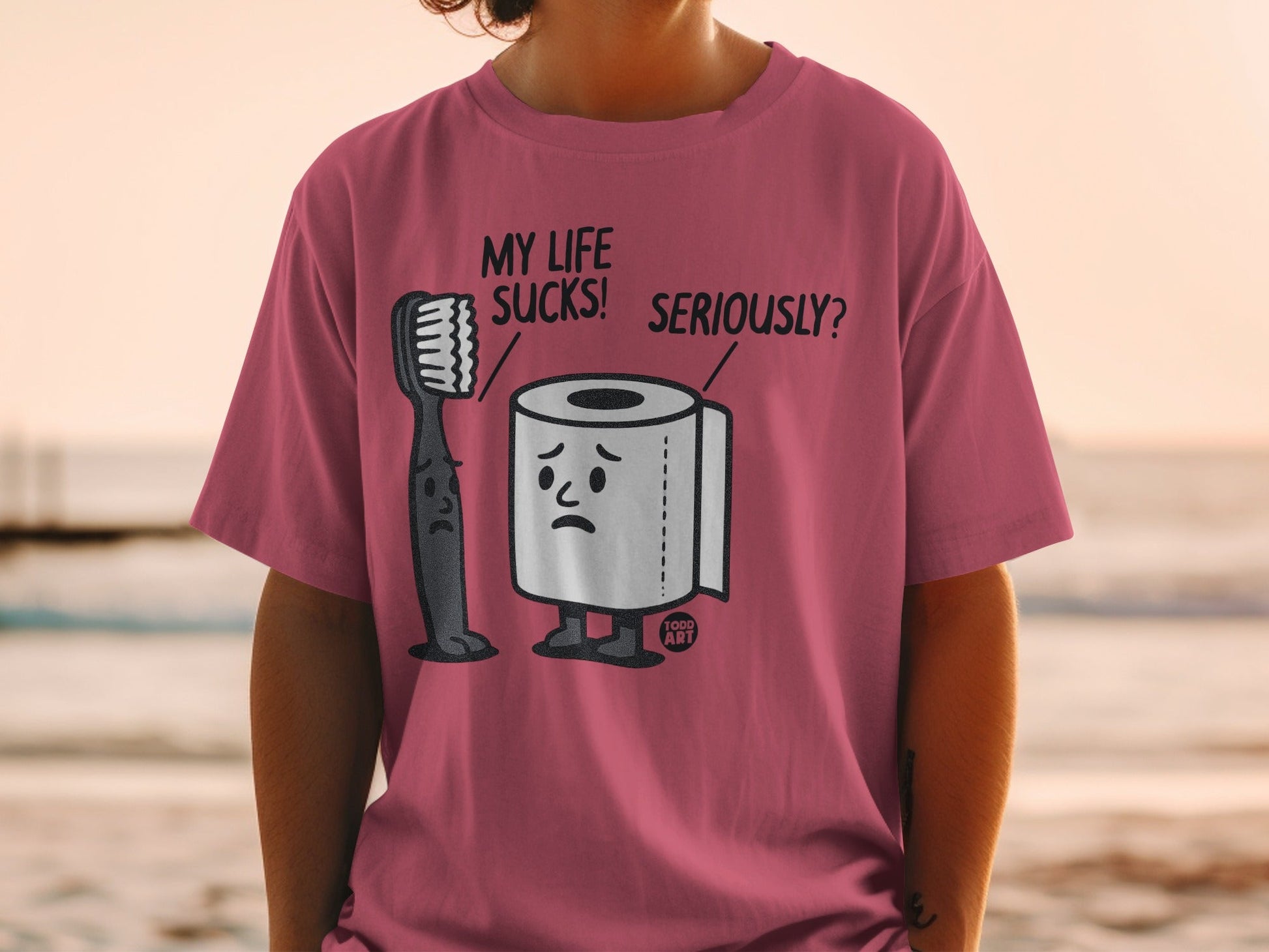 T-shirt with cartoon toothbrush and toilet paper characters and text.