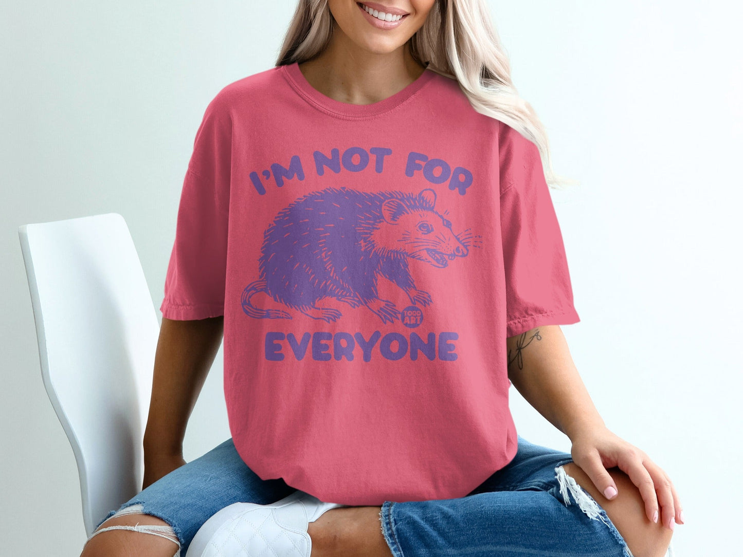 Pink t-shirt with purple opossum graphic and "I'm not for everyone" text.