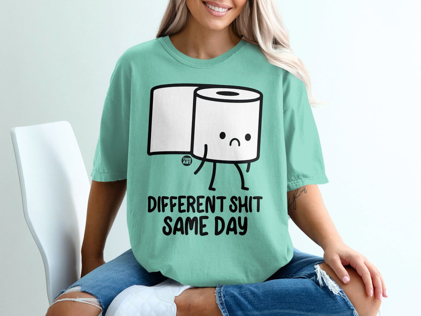 Mint t-shirt with cartoon toilet paper roll saying "Different Shit, Same Day."