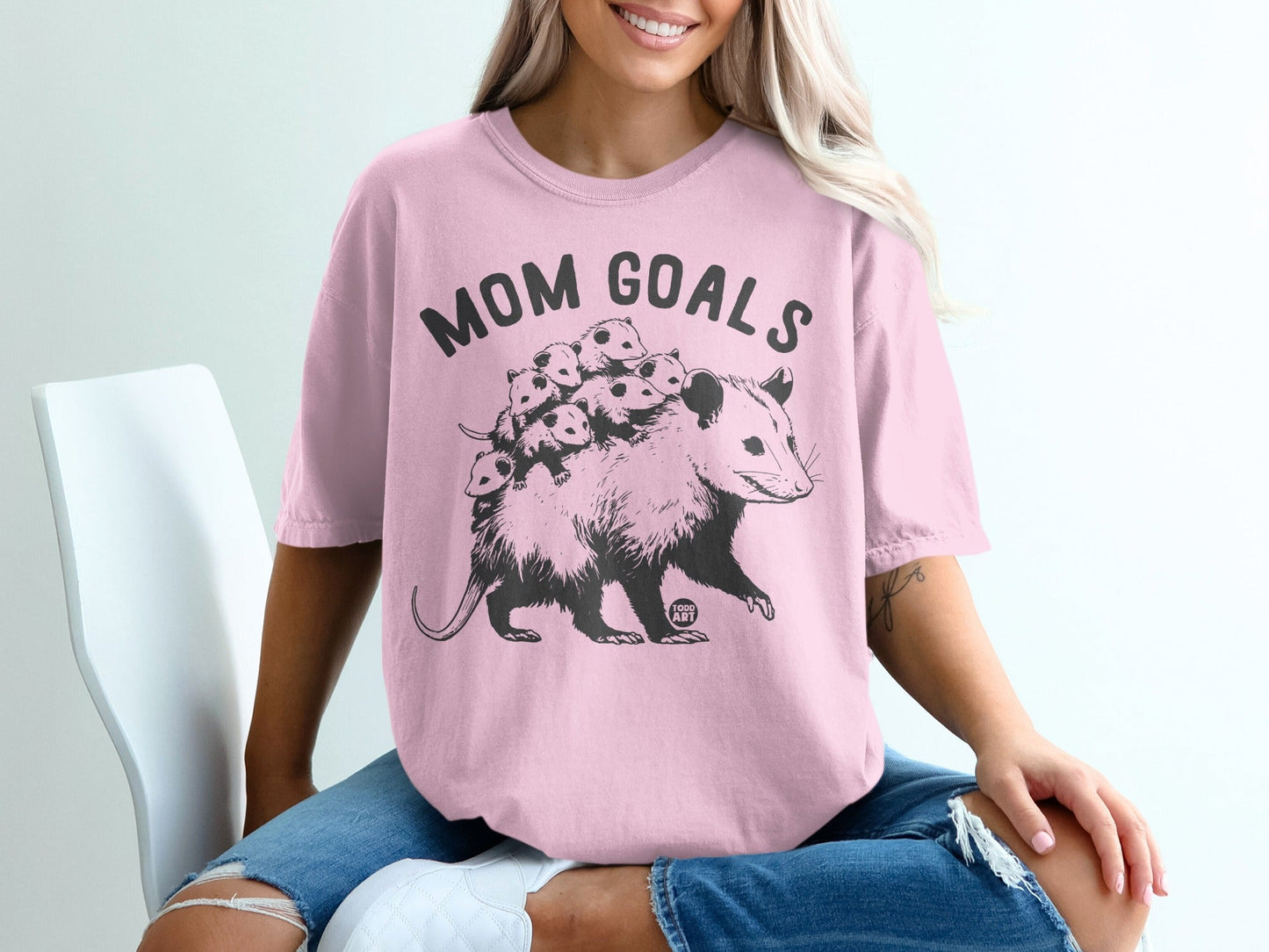 Black opossum with babies on back, reads "MOM GOALS" in large text.