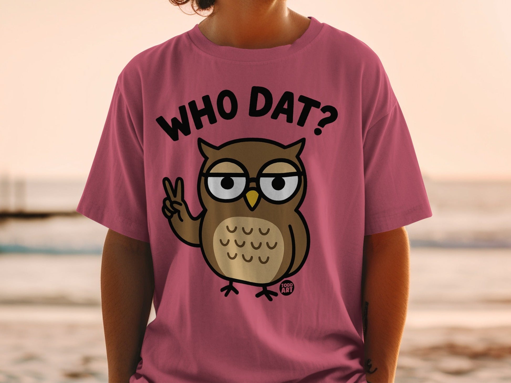 Pink t-shirt with cartoon owl wearing glasses and saying "WHO DAT?".