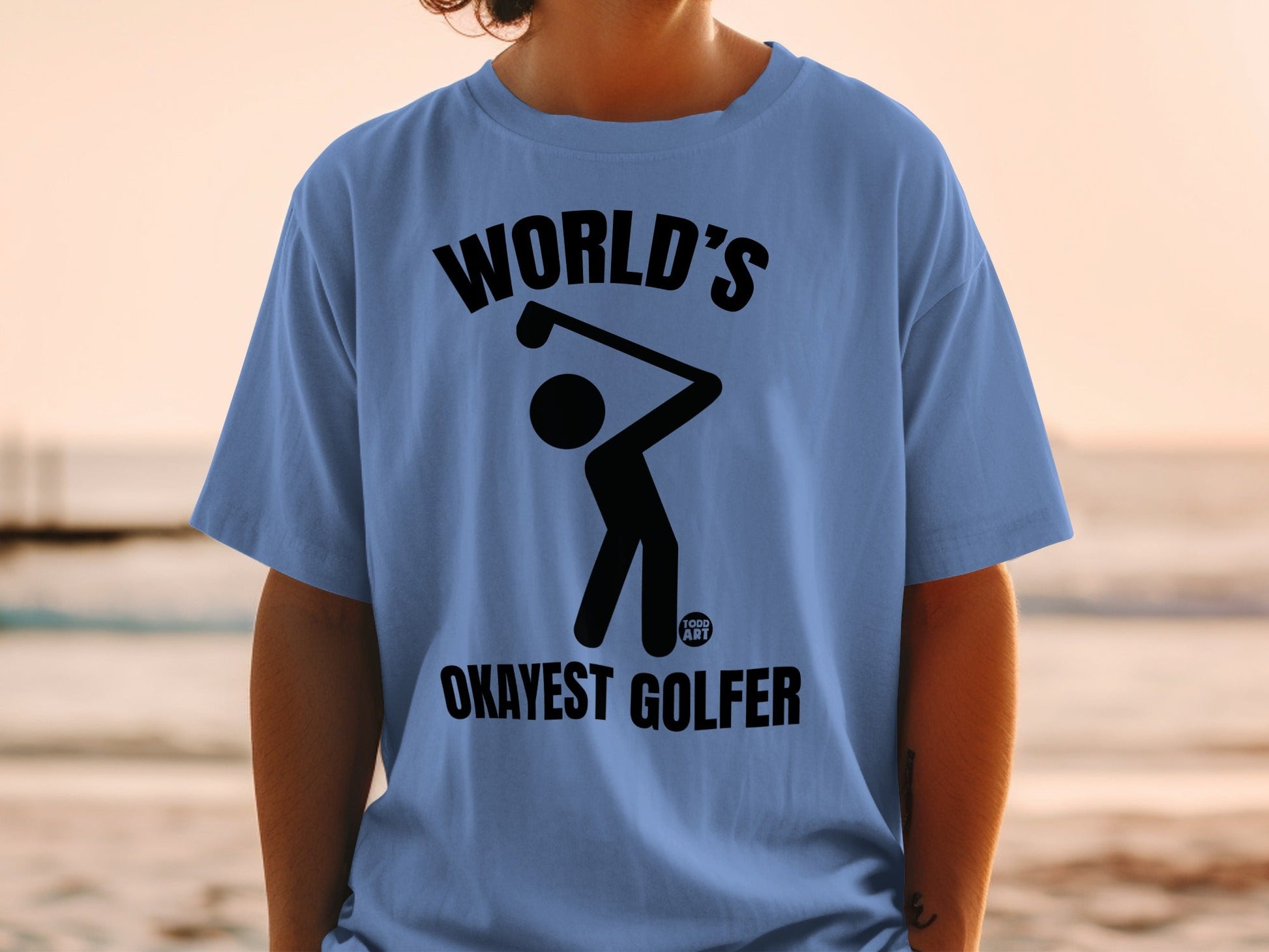 Blue t-shirt with graphic of a golfer and text "WORLD'S OKAYEST GOLFER".