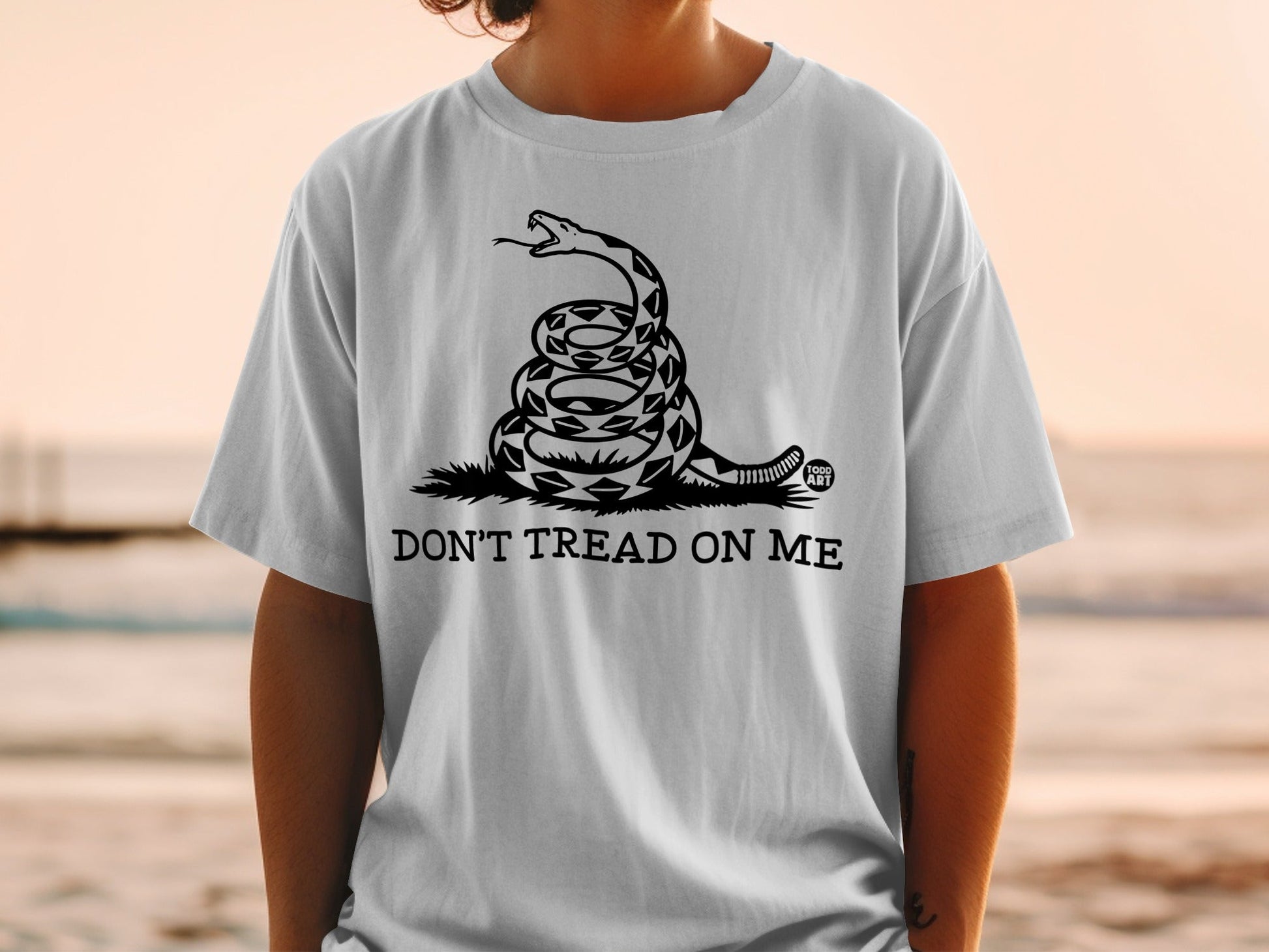 White t-shirt with coiled rattlesnake and "Don't Tread On Me" text.