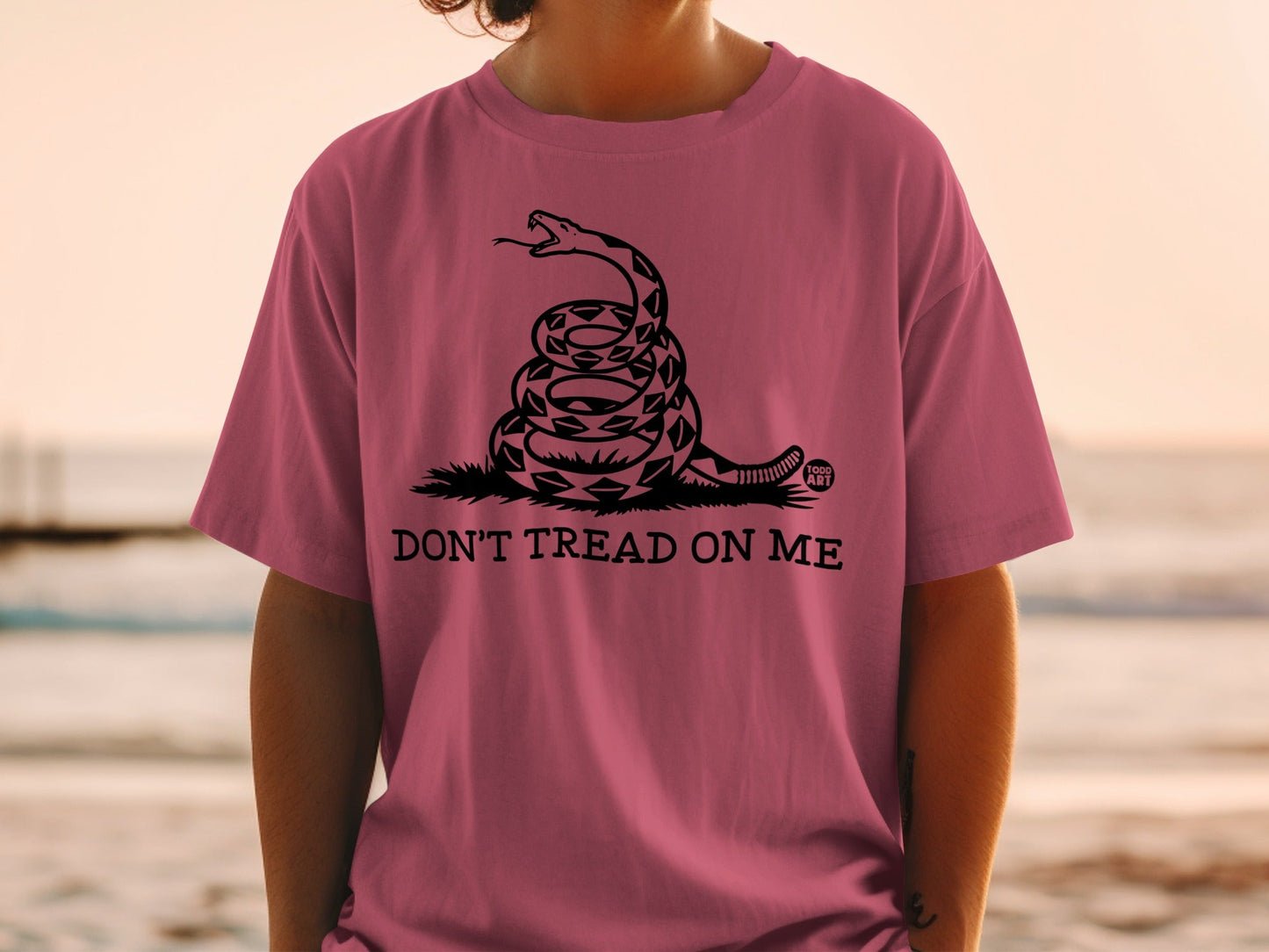 Pink t-shirt with coiled rattlesnake and "DON'T TREAD ON ME" text.