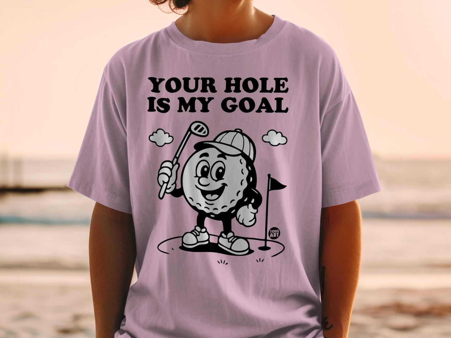 Light purple t-shirt with cartoon golf ball saying "YOUR HOLE IS MY GOAL."