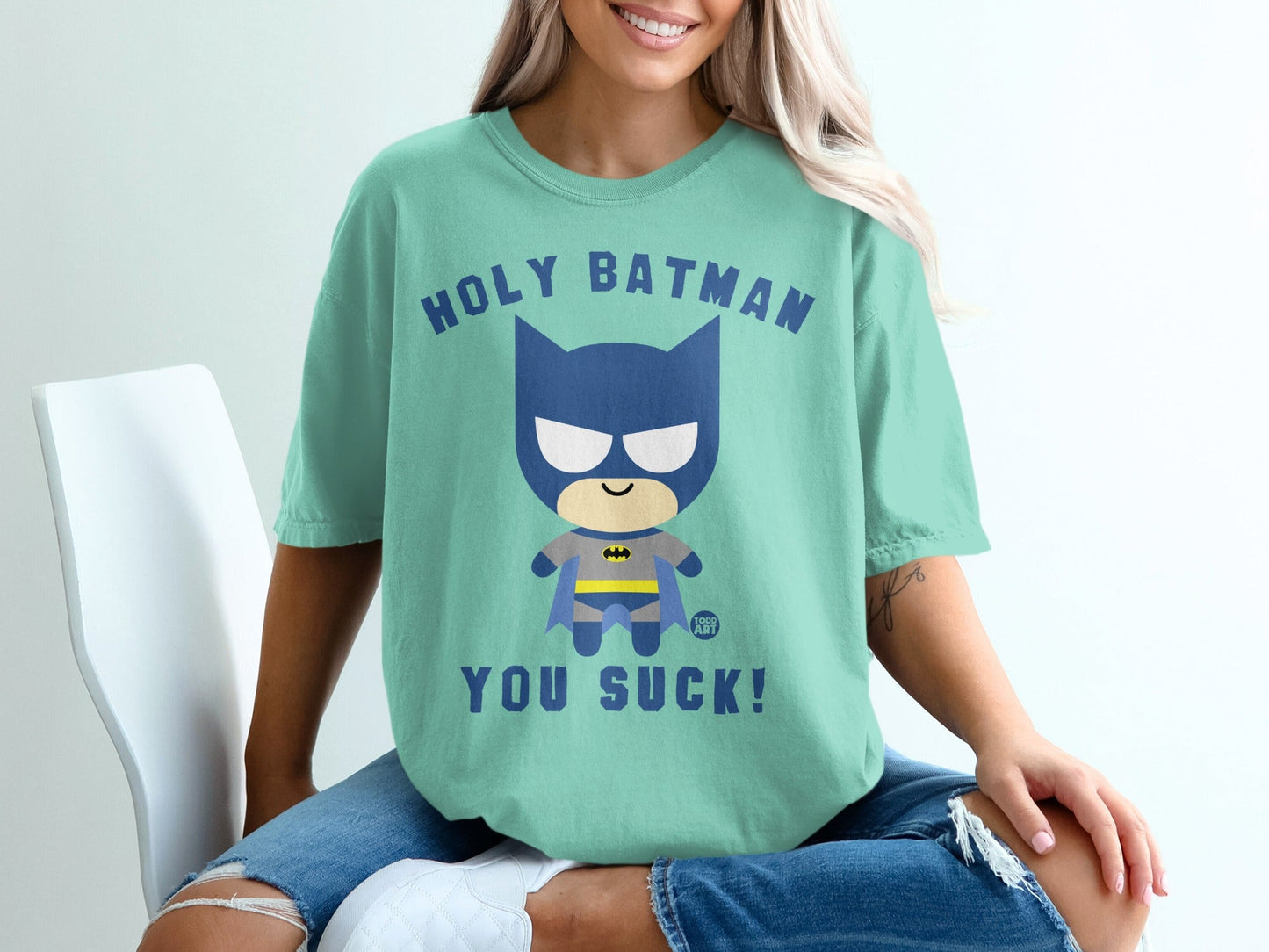 Teal t-shirt with cartoon Batman saying "Holy Batman, You Suck!".
