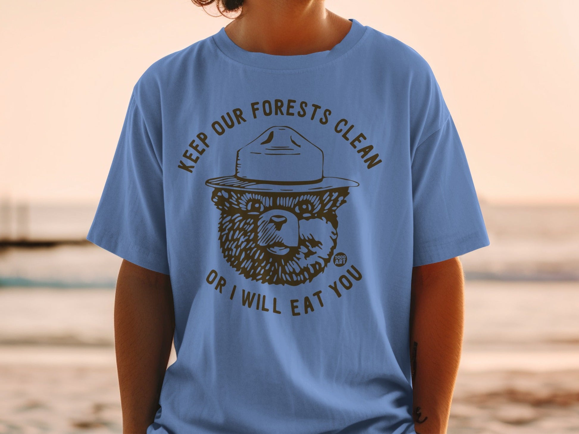 Blue t-shirt with Smokey Bear saying "Keep Our Forests Clean Or I Will Eat You".