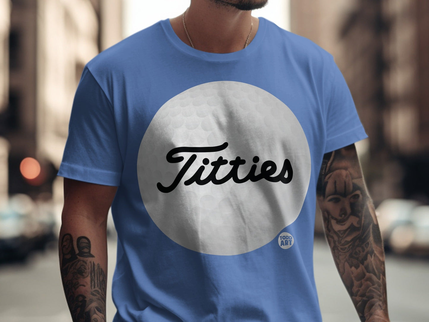 Blue t-shirt with "Titties" text over a golf ball graphic.