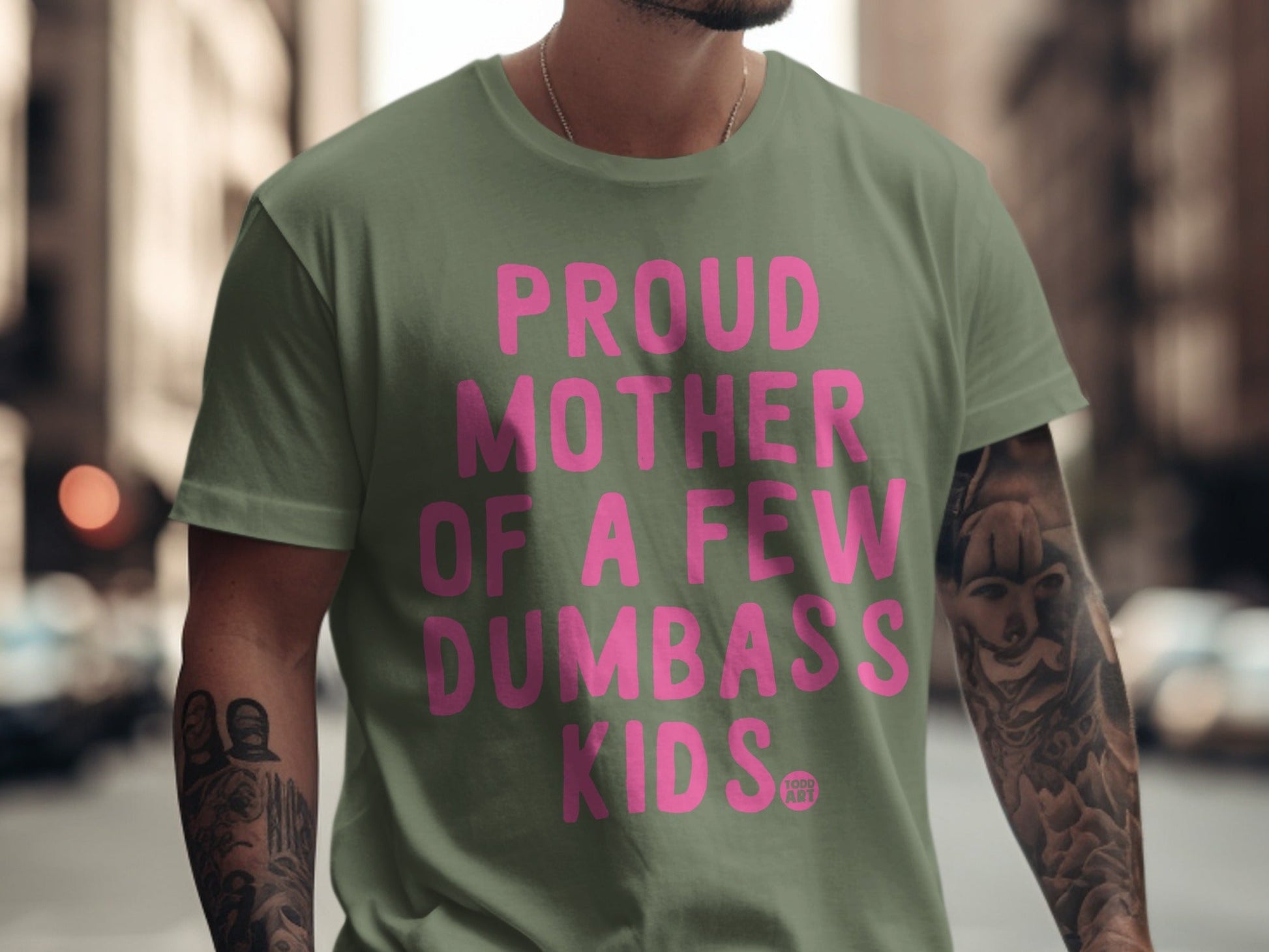Green t-shirt with pink text that reads "Proud Mother of a Few Dumbass Kids."