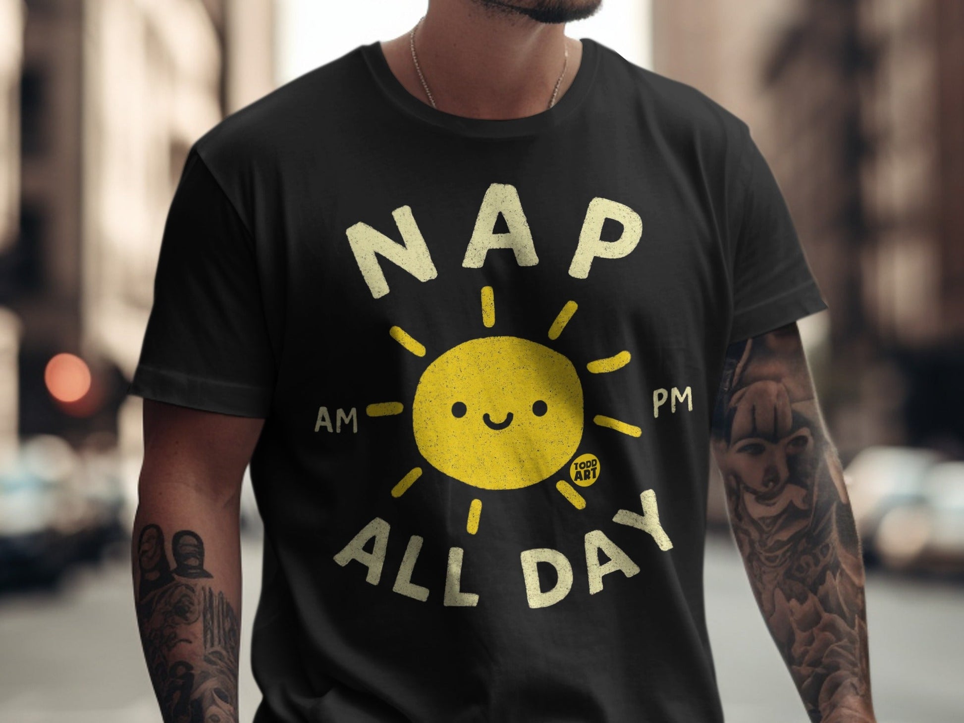 Black t-shirt with a smiling sun graphic and "NAP ALL DAY" text.