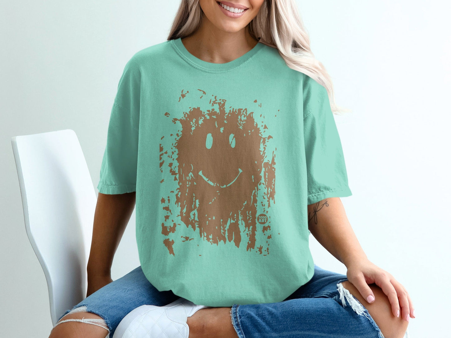 Teal t-shirt with distressed brown smiley face graphic.