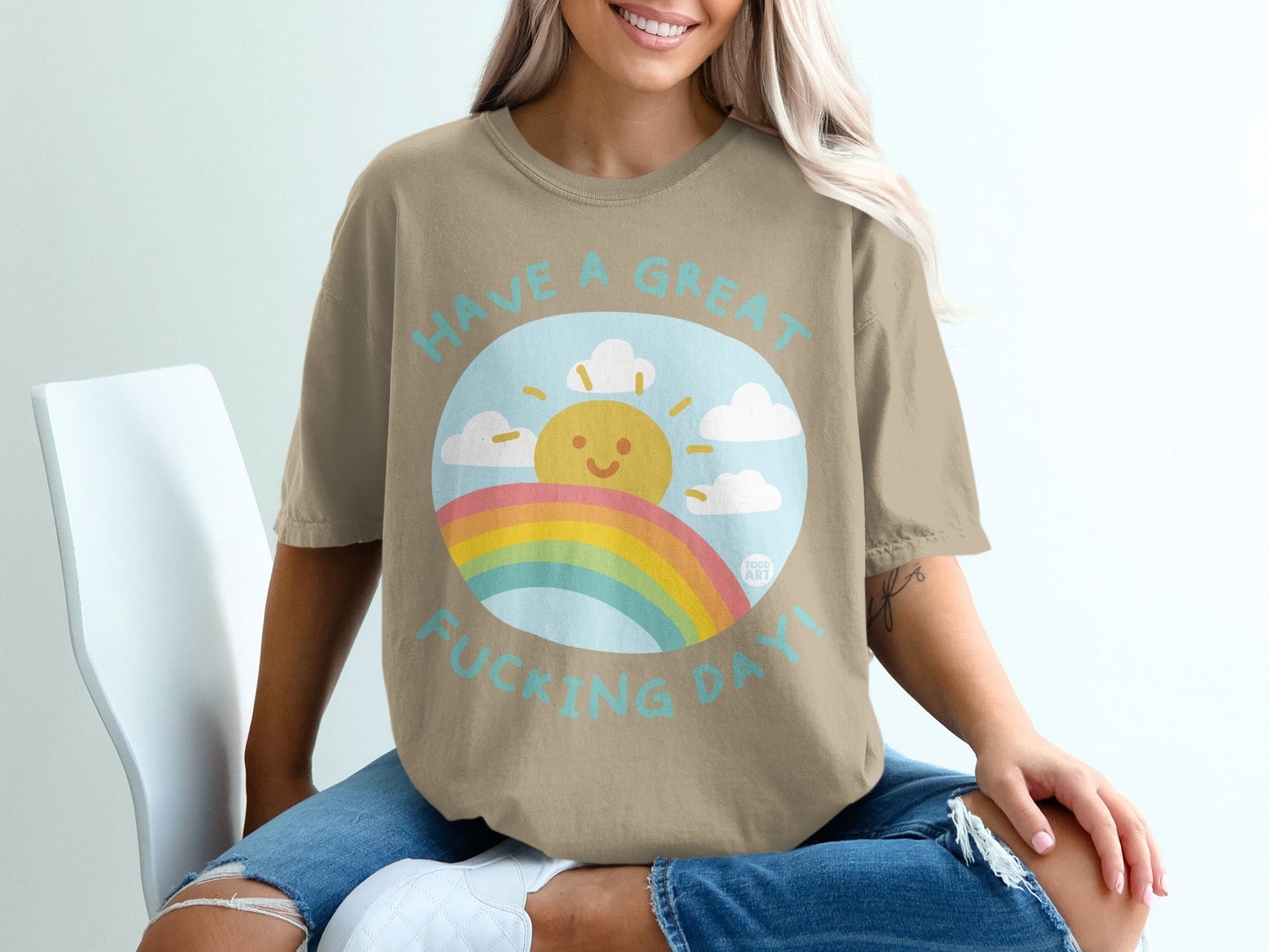 T-shirt with sun, clouds, and rainbow, text "Have a great fucking day!".