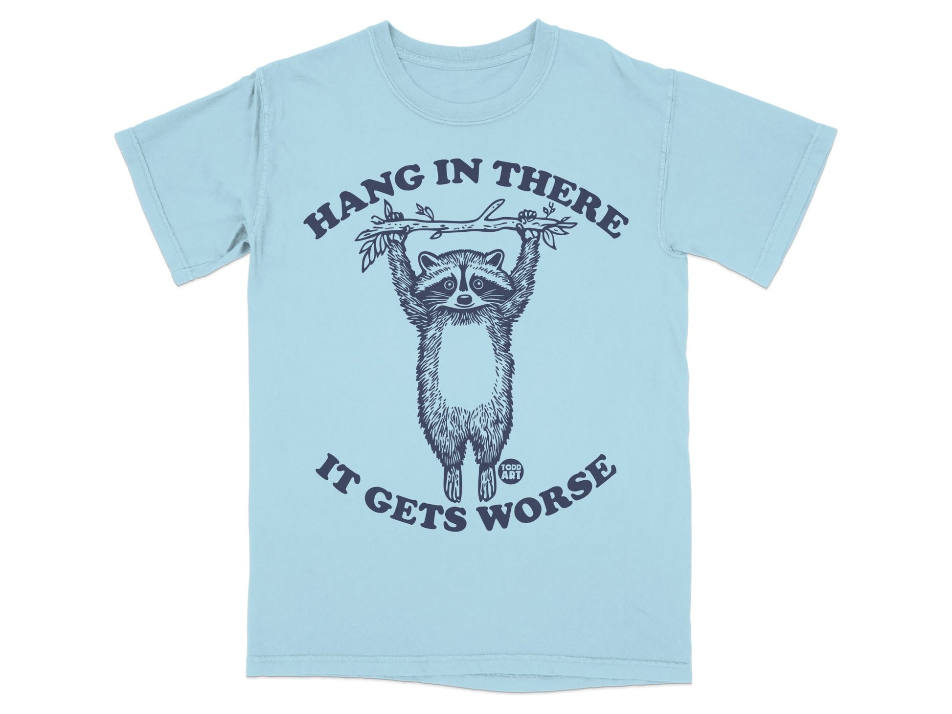 Light blue t-shirt with raccoon hanging from branch, text "Hang in There It Gets Worse".