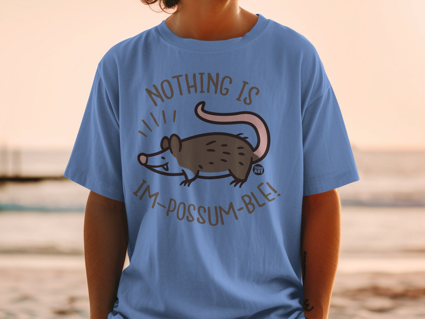 Blue t-shirt with a cartoon possum and text: Nothing is Im-possum-ble!