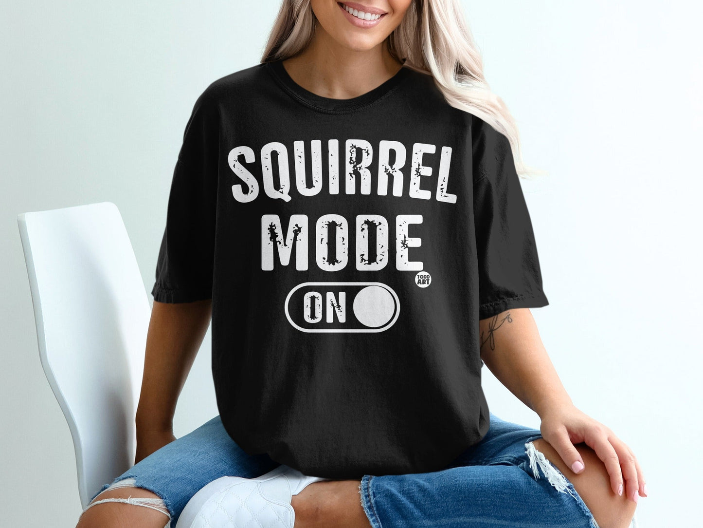 Black t-shirt with white "SQUIRREL MODE ON" text and circular logo.