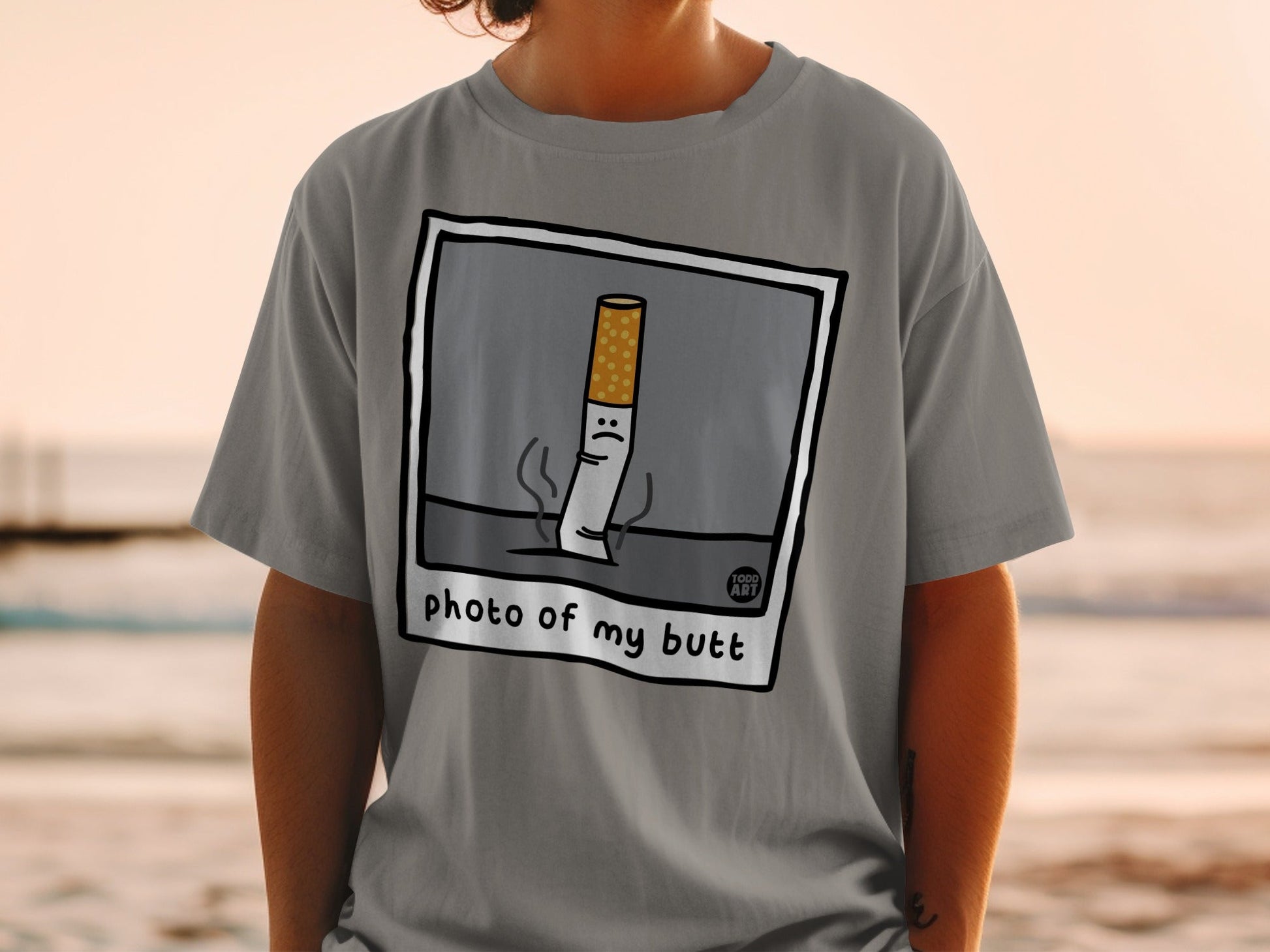T-shirt with cartoon cigarette with sad face and text "photo of my butt".