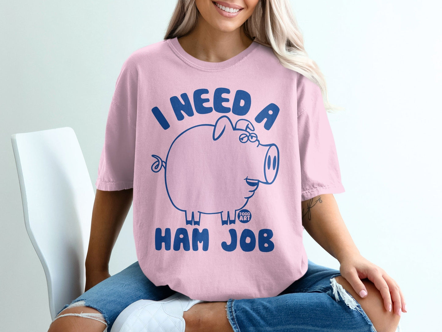 Pink t-shirt with blue outline of a piggy bank and text "I NEED A HAM JOB".