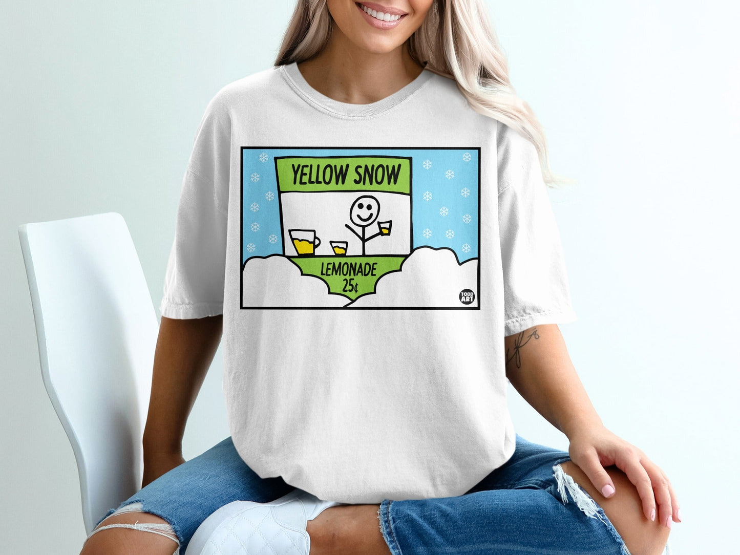 T-shirt with cartoon of lemonade stand and "Yellow Snow Lemonade" sign.