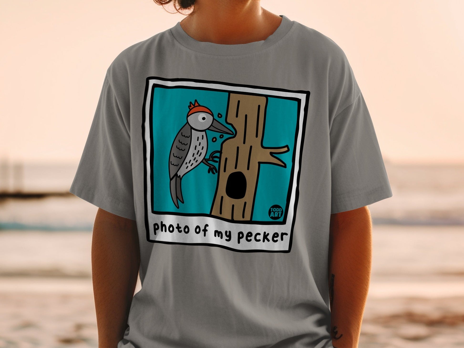 T-shirt with cartoon woodpecker on a tree and text "photo of my pecker".