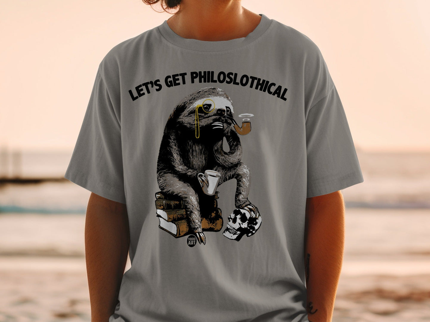 T-shirt with a sloth wearing a monocle, holding a pipe and coffee, sitting on books and a skull.