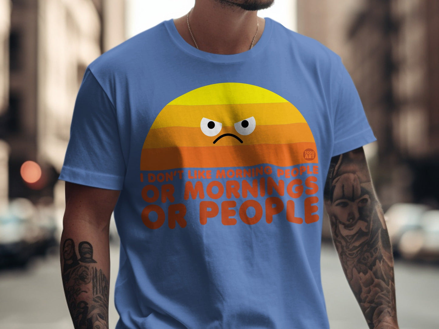 Blue t-shirt with orange sunrise graphic and "I DON'T LIKE MORNING PEOPLE OR PEOPLE" text.