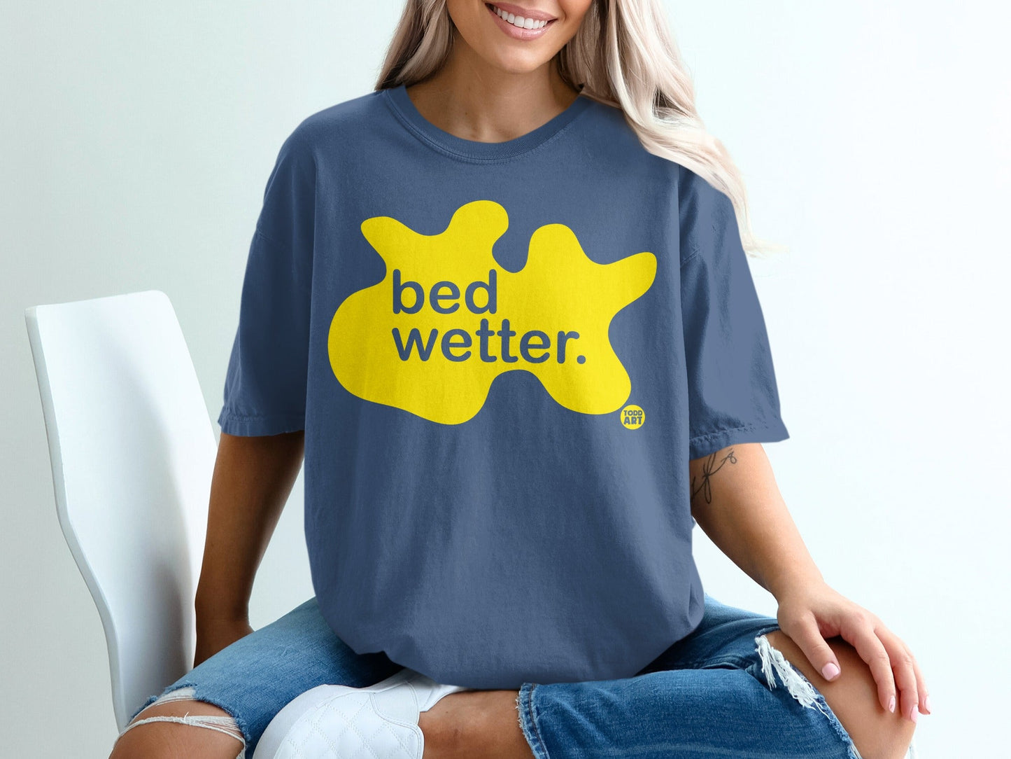 Dark blue t-shirt with yellow splat graphic and "bed wetter." text.