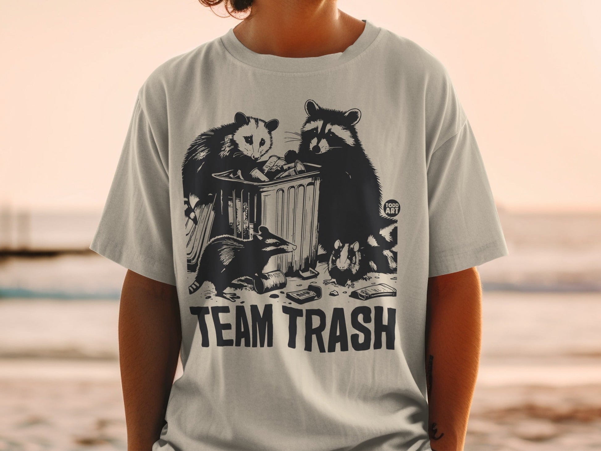 T-shirt with raccoons and an opossum around a trash can, reads "TEAM TRASH".