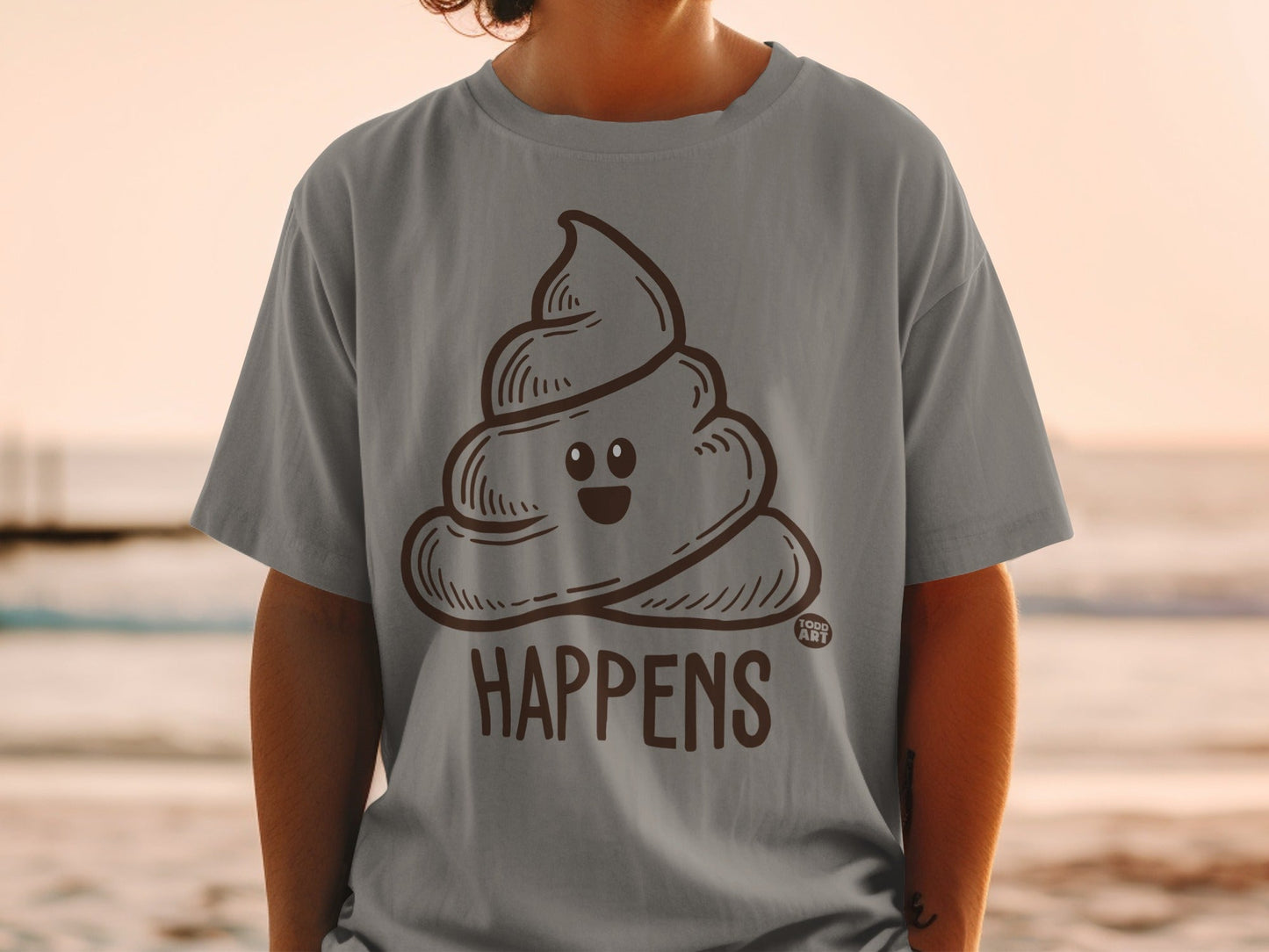 Brown cartoon poop emoji on gray t-shirt with "HA PPENS" text.