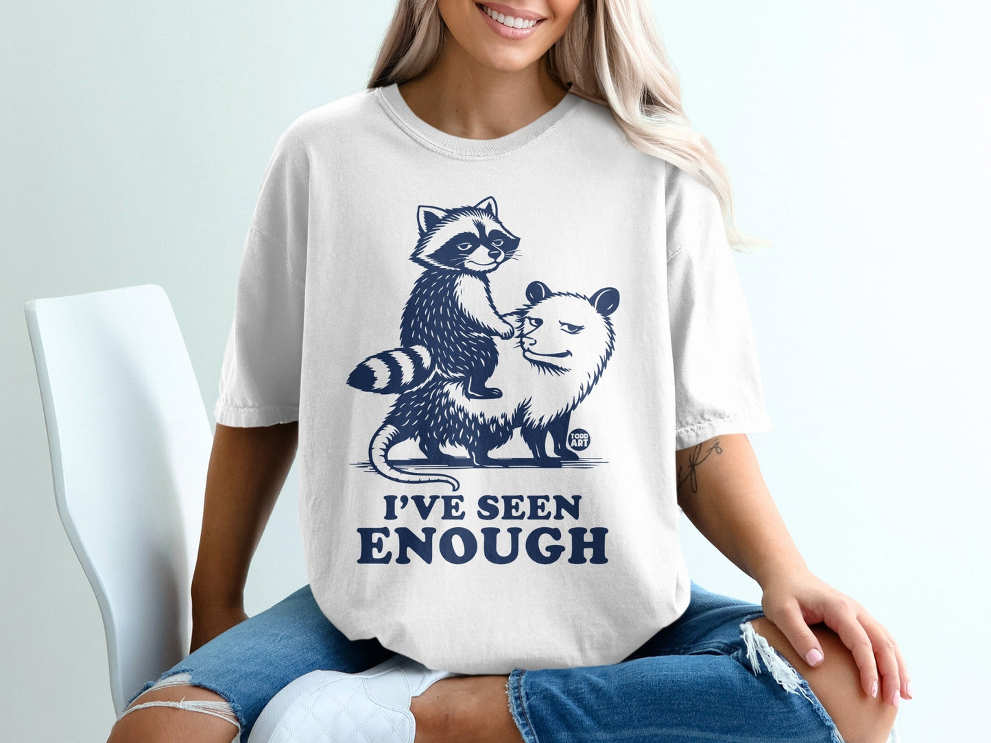 White t-shirt with raccoon riding opossum graphic and "I'VE SEEN ENOUGH" text.