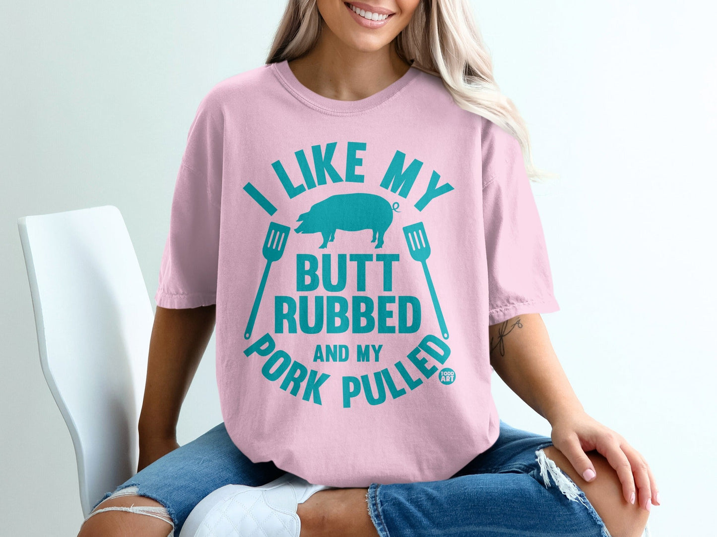 Pink t-shirt with text "I LIKE MY BUTT RUBBED AND MY PORK PULLED" and pig graphic.