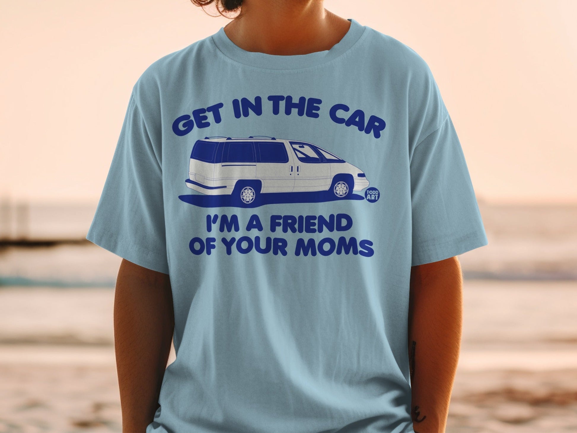 Light blue t-shirt with white van and text "GET IN THE CAR I'M A FRIEND OF YOUR MOMS".