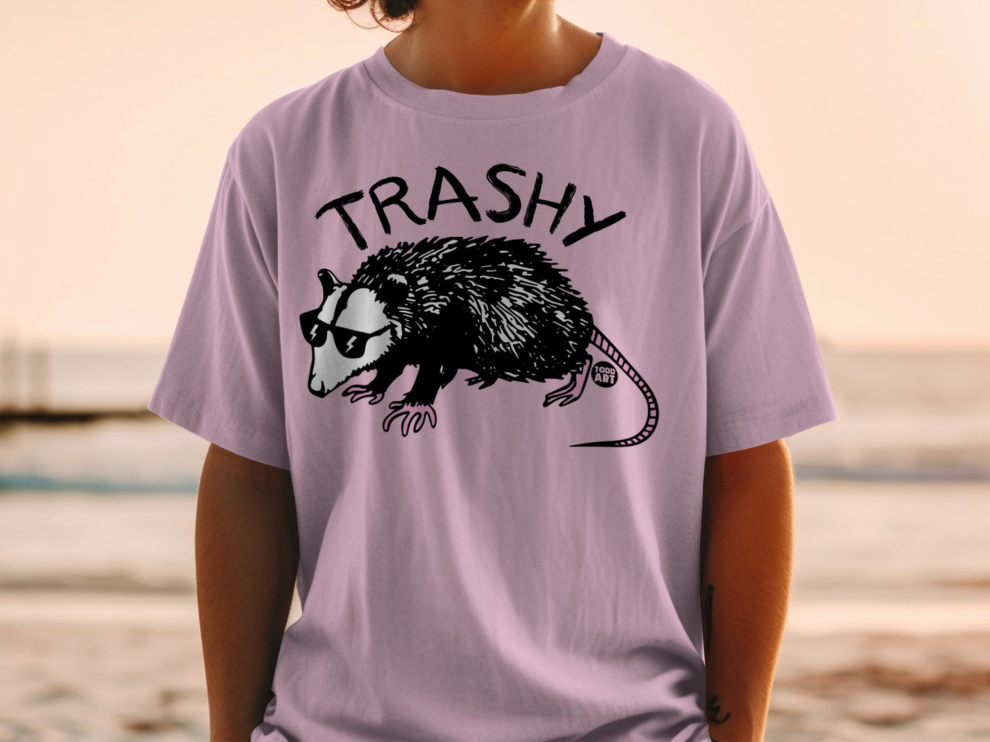 T-shirt with a black opossum wearing sunglasses and "TRASHY" text.