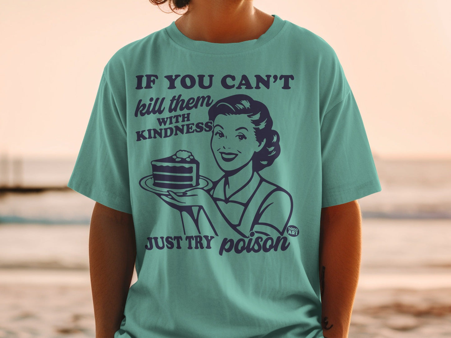 Teal t-shirt with retro woman holding cake and text "If you can't kill them with kindness, just try poison".