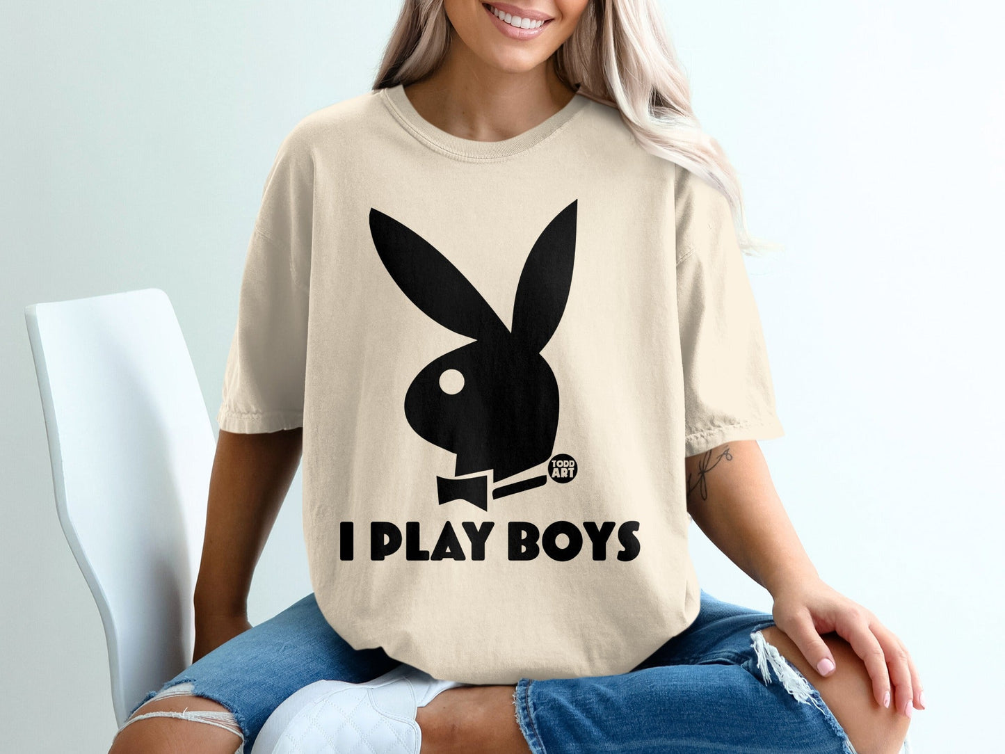 Cream t-shirt with black Playboy bunny logo and "I PLAY BOYS" text.