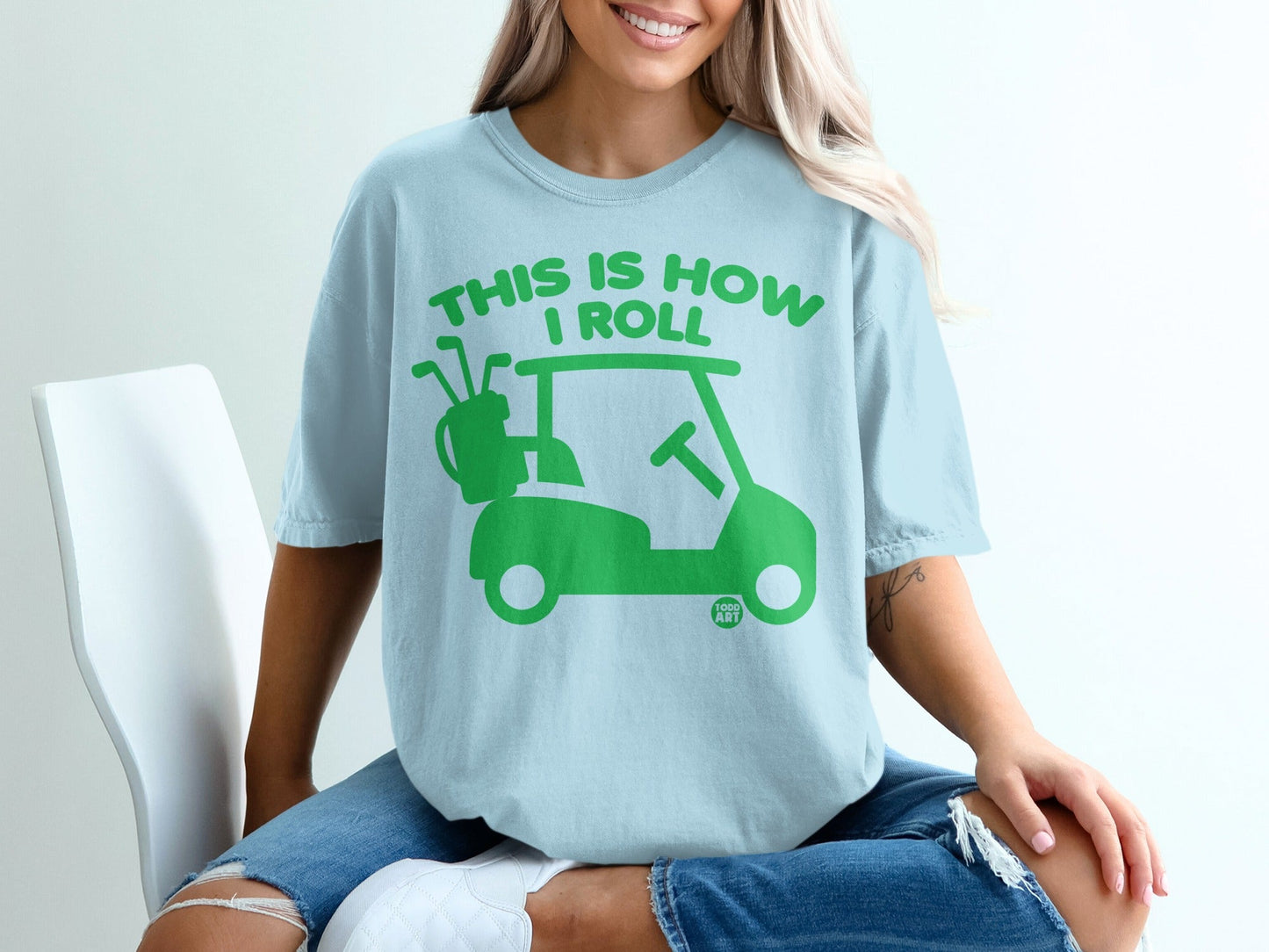 Light blue t-shirt with green golf cart graphic and text "This is how I roll".