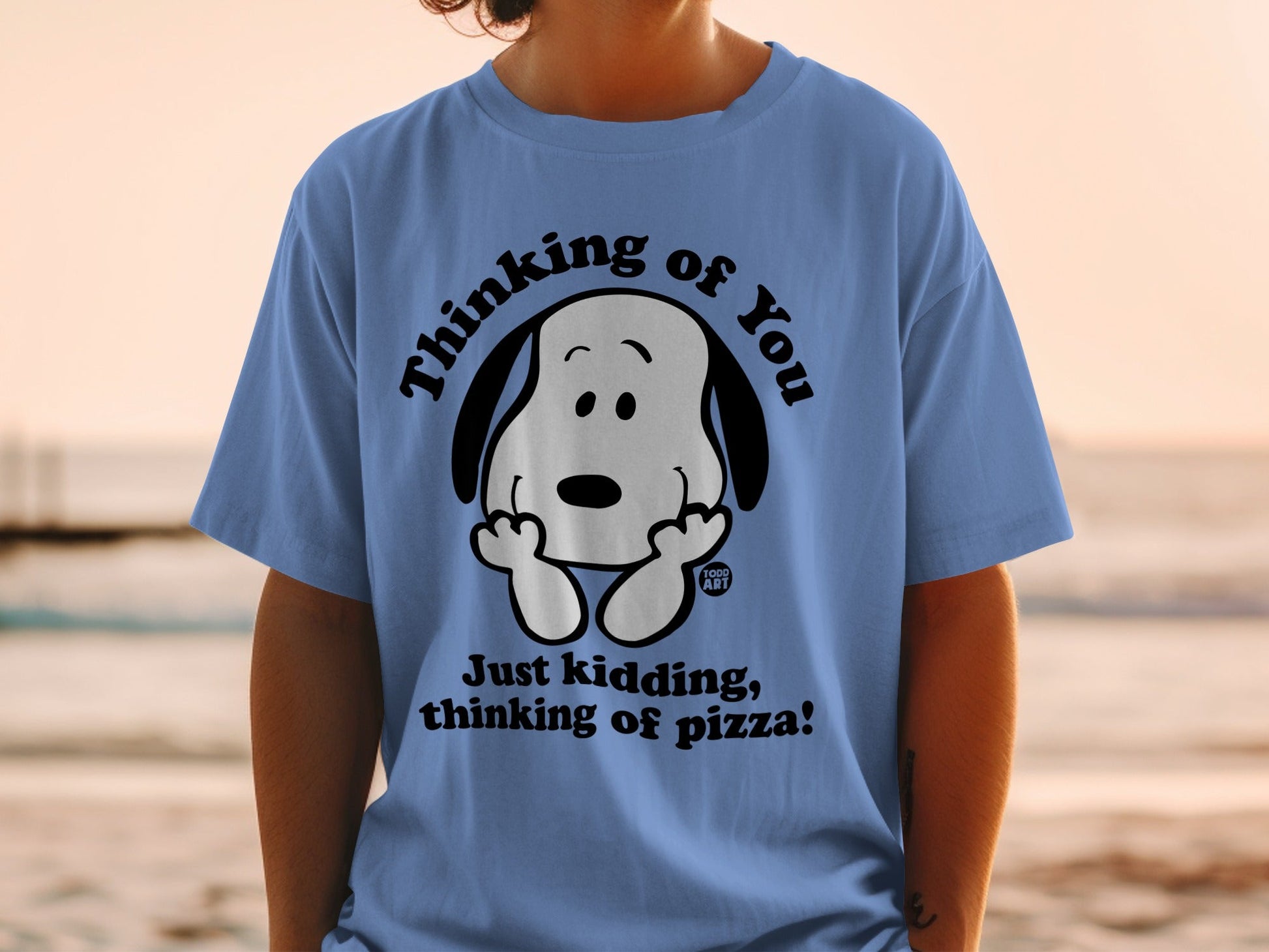 Blue t-shirt with Snoopy thinking of pizza text and graphic.