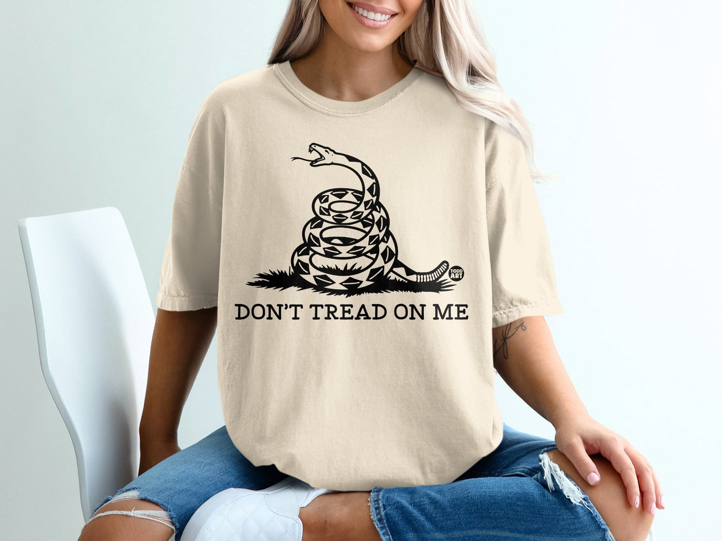 Cream t-shirt with coiled snake and "DON'T TREAD ON ME" text.